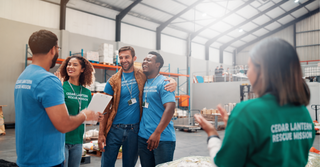 Illustrative rescue-mission team celebrating together in a supply warehouse.