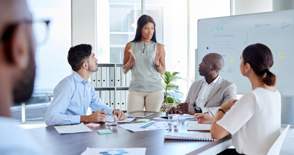 A woman leading a team discussion around a meeting table.