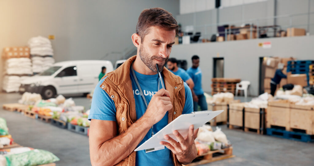 A volunteer manages food donation inventory at a nonprofit food bank warehouse.